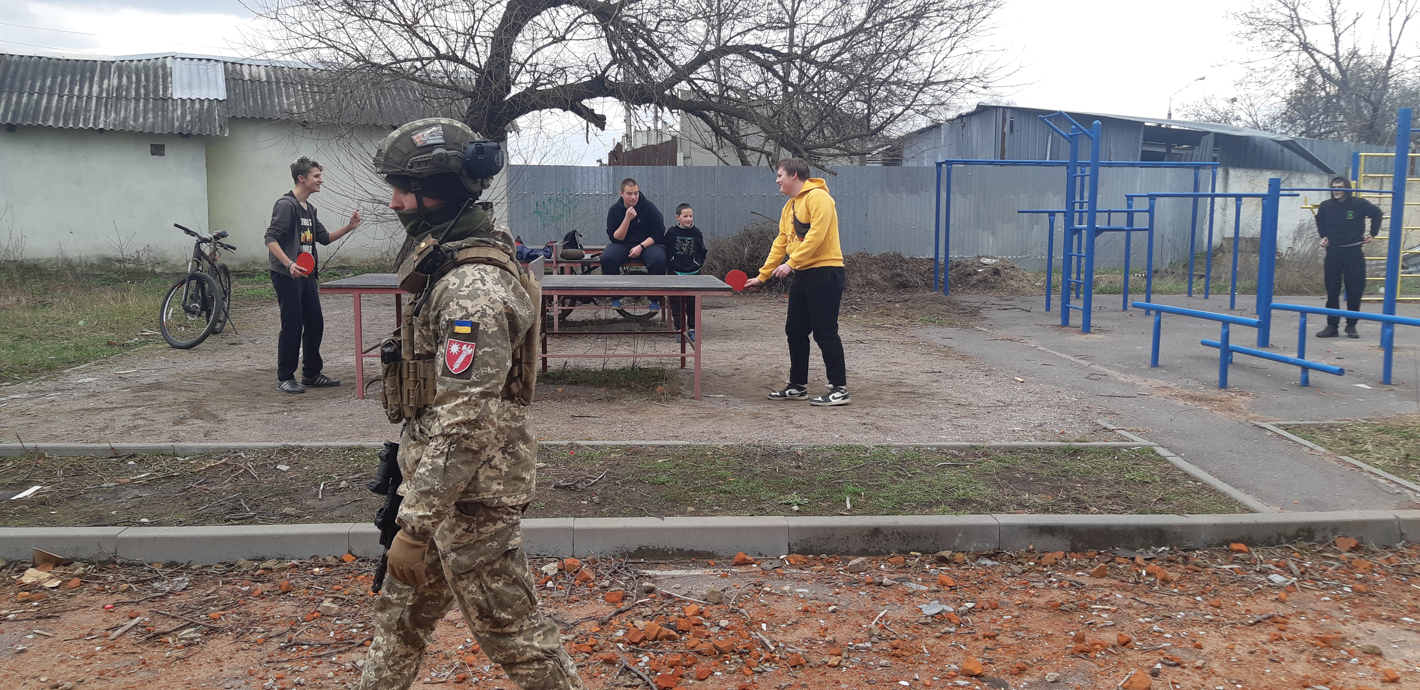 Ukrainian serviceman and teenagers in war-affected town