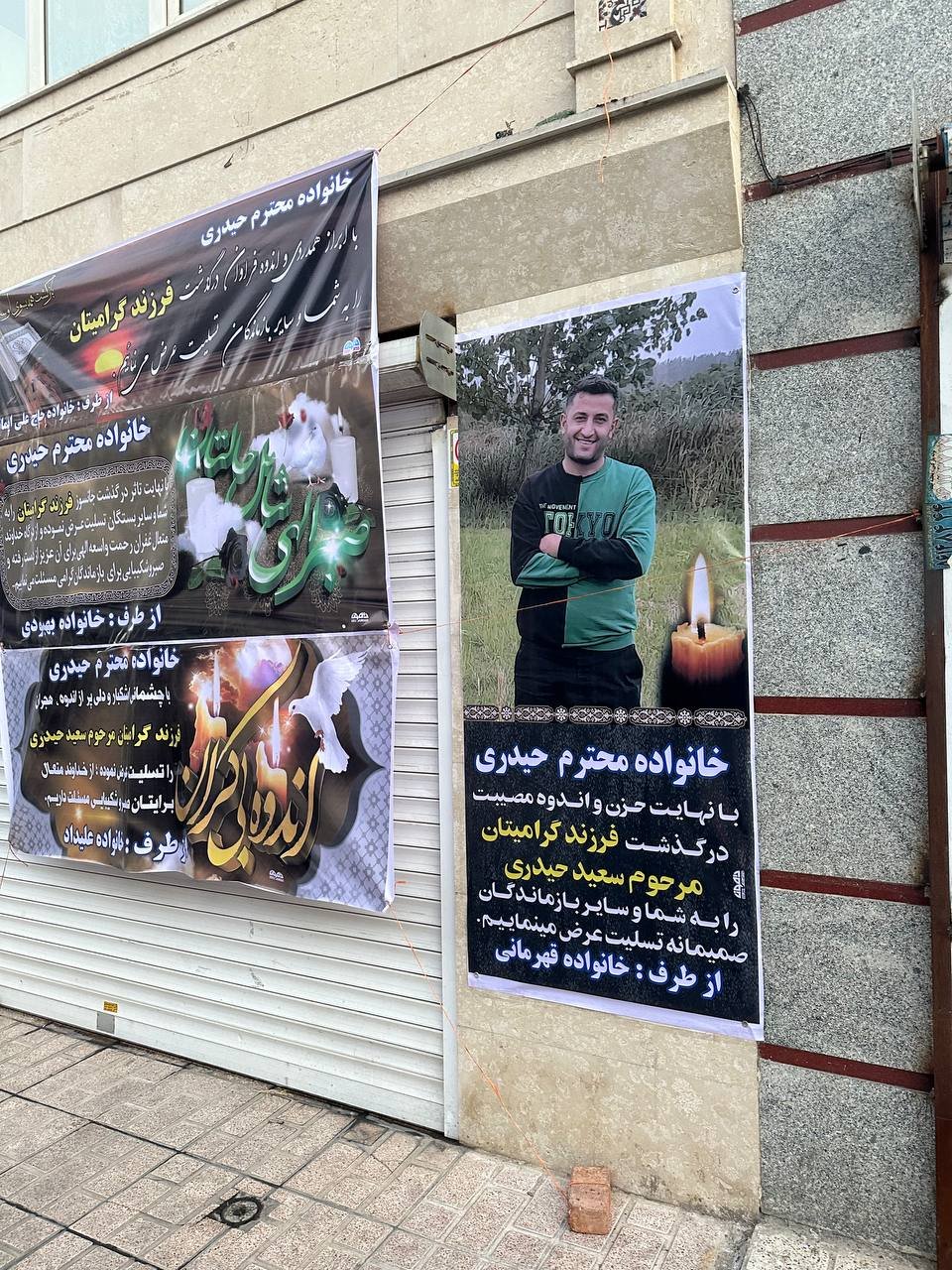 Persian-language condolence and mourning banners on a street wall in Iran
