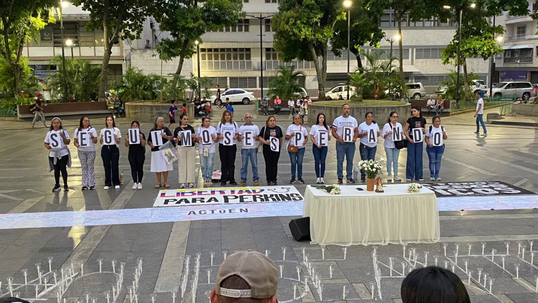 Activists spell out 'Seguimos esperando' in a Venezuelan plaza