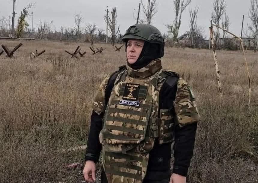 A military chaplain in body armour at the front