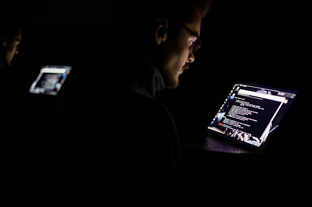 A person at a laptop in the dark