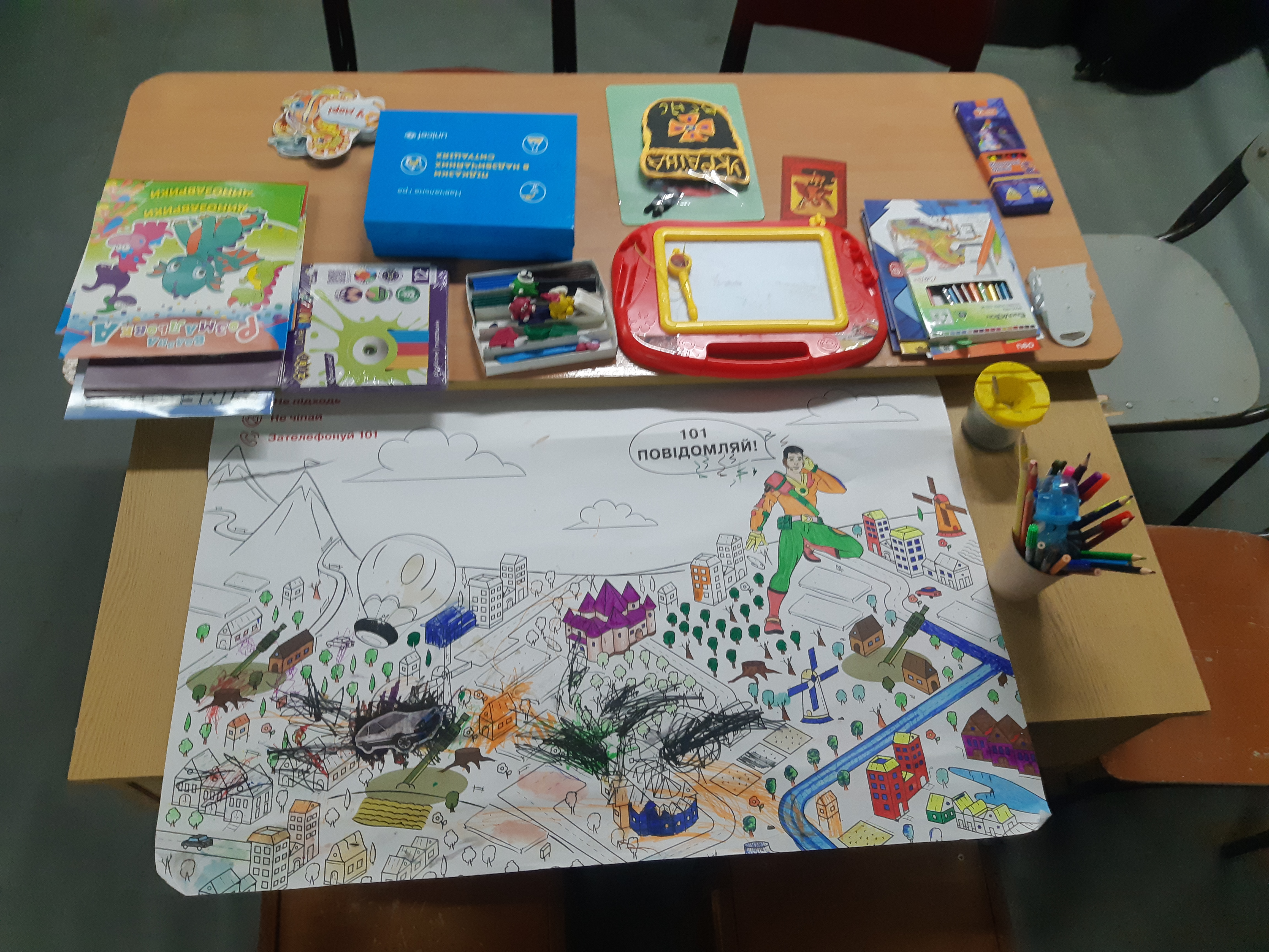 Children's drawing materials and a war-themed colouring poster in Ukraine