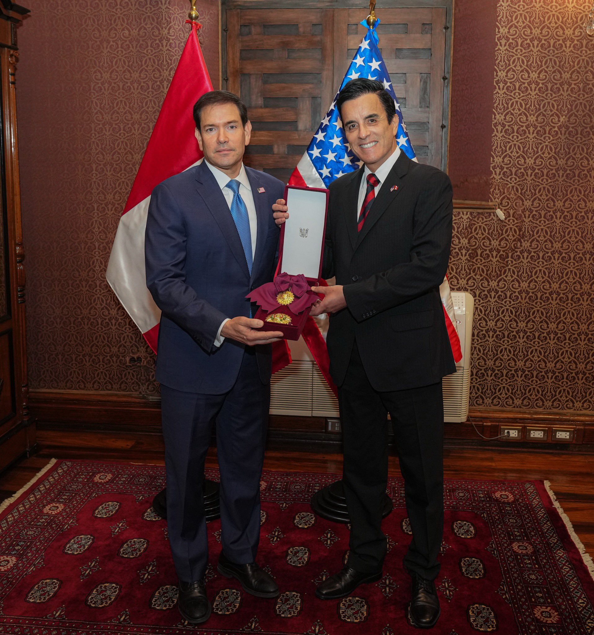 Marco Rubio receives a Peruvian state decoration, with the Peruvian and U.S. flags behind